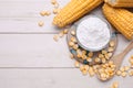 Bowl with corn starch, ripe cobs and kernels on wooden table, flat lay. Space for text Royalty Free Stock Photo