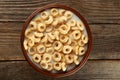 Bowl of cornflakes with milk on brown wooden background. Royalty Free Stock Photo