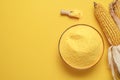 Cornflour in a bowl top view. Bowl with polenta isolated on yellow background