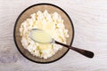 Bowl of cottage cheese with condensed milk, spoon on table. Top view Royalty Free Stock Photo