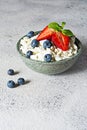 A bowl with cottage cheese, yogurt, fresh berries blueberries, strawberries and fresh mint on a gray background. Royalty Free Stock Photo