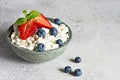 A bowl with cottage cheese, yogurt, fresh berries blueberries, strawberries and fresh mint on a gray background. Royalty Free Stock Photo