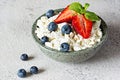 A bowl with cottage cheese, yogurt, fresh berries blueberries, strawberries and fresh mint on a gray background. Royalty Free Stock Photo