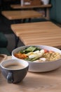 A bowl of couscous, meat, eggs and avocado and vegetables and a cup of coffee on cafe table. Royalty Free Stock Photo
