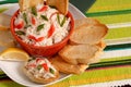 Bowl of crab dip with toasted crostini and lemon