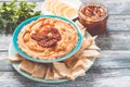 A bowl of creamy homemade hummus with with sun-dried tomatoes, olive oil and pita chips. traditional vegan healthy meal