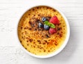 Bowl of creme brule on white wooden table Royalty Free Stock Photo