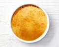 Bowl of creme brule on white wooden table Royalty Free Stock Photo