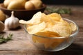 Bowl of crispy potato chips on wooden table. Royalty Free Stock Photo