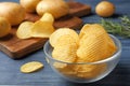 Bowl of crispy potato chips on wooden table Royalty Free Stock Photo