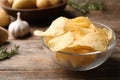 Bowl of crispy potato chips on wooden table Royalty Free Stock Photo