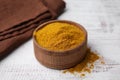 Bowl with curry powder on white wooden table, closeup Royalty Free Stock Photo