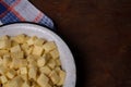 Bowl of cut sweet potato or yam on wooden table with kitchen towel. Top view. Nutricious tasty vegetarian food, local farmer Royalty Free Stock Photo