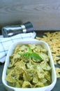 Bowl of Homemade Farfalle Pasta with Pesto Sauce on Kitchen Table Royalty Free Stock Photo