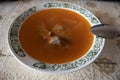 A bowl of delicious beef and barley soup with carrots, tomato, potato, celery, and peas. Tomato broth with meat Royalty Free Stock Photo