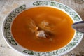 A bowl of delicious beef and barley soup with carrots, tomato, potato, celery, and peas. Tomato broth with meat Royalty Free Stock Photo