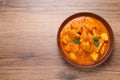 Bowl of delicious chicken curry on wooden table, top view. Space for text Royalty Free Stock Photo