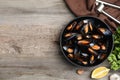 Bowl of delicious cooked mussels with parsley and lemon on wooden table, flat lay Royalty Free Stock Photo