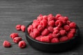 Bowl of delicious fresh ripe raspberries on dark wooden table, space Royalty Free Stock Photo