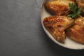 Bowl with delicious fried chicken wings on black table, top view. Space for text Royalty Free Stock Photo