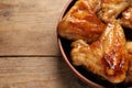 Bowl with delicious fried chicken wings on wooden table, closeup. Space for text Royalty Free Stock Photo