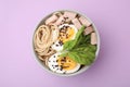 Bowl of delicious ramen with meat and egg on violet table, top view. Noodle soup