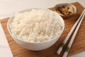 Bowl with delicious rice, mushrooms and chopsticks on white table, closeup Royalty Free Stock Photo