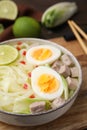 Bowl of delicious rice noodle soup with meat and egg on wooden board, closeup Royalty Free Stock Photo