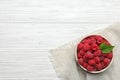 Bowl with delicious ripe raspberries on white wooden table, top view Royalty Free Stock Photo