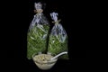 Bowl of a delicious salad with two bags of dried spices isolated on a black background