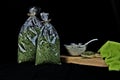 Bowl of a delicious salad with two bags of dried spices isolated on a black background