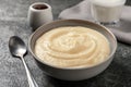 Bowl with delicious semolina pudding on grey table