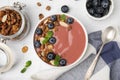 Bowl of delicious smoothie served with fresh blueberries and granola on white tiled table, flat lay Royalty Free Stock Photo