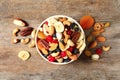 Bowl with different dried fruits and nuts on wooden background Royalty Free Stock Photo