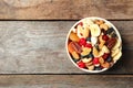 Bowl with different dried fruits and nuts on wooden background, top view. Royalty Free Stock Photo