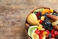 Bowl of different dried fruits on wooden background, top view with space for text Royalty Free Stock Photo