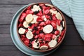 Bowl of different freeze dried fruits on wooden table, top view