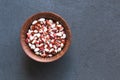 Bowl of different haricot beans on the stone table, top view