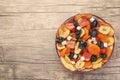 Bowl with different tasty dried fruits on wooden table, top view. Space for text Royalty Free Stock Photo