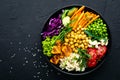 Bowl dish with brown rice, cucumber, tomato, green peas, red cabbage, chickpea, fresh lettuce salad and cashew nuts. Healthy balan Royalty Free Stock Photo