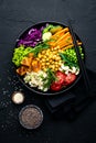 Bowl dish with brown rice, cucumber, tomato, green peas, red cabbage, chickpea, fresh lettuce salad and cashew nuts. Healthy balan Royalty Free Stock Photo