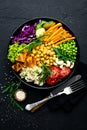 Bowl dish with brown rice, cucumber, tomato, green peas, red cabbage, chickpea, fresh lettuce salad and cashew nuts. Healthy balan Royalty Free Stock Photo