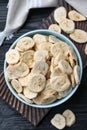 Bowl and dried banana slices on black wooden table, top view Royalty Free Stock Photo