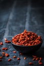 Bowl with dried Goji berries, chinese wolfberries, on black background Royalty Free Stock Photo