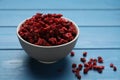 Bowl of dried red currant berries on blue wooden table Royalty Free Stock Photo