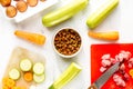 Bowl of dry dogfood, carrot, courgette and meat table background top view Royalty Free Stock Photo