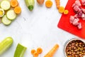Bowl of dry dogfood, carrot, courgette, meat table background top view mock-up Royalty Free Stock Photo