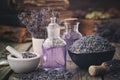 Bowl of dry lavender flowers, mortars, bottles of essential lavender oil or infused water. Old books and medicinal herbs on Royalty Free Stock Photo