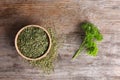 Bowl with dry parsley on wooden background Royalty Free Stock Photo