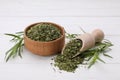 Bowl of dry tarragon, scoop and fresh leaves on white wooden table Royalty Free Stock Photo